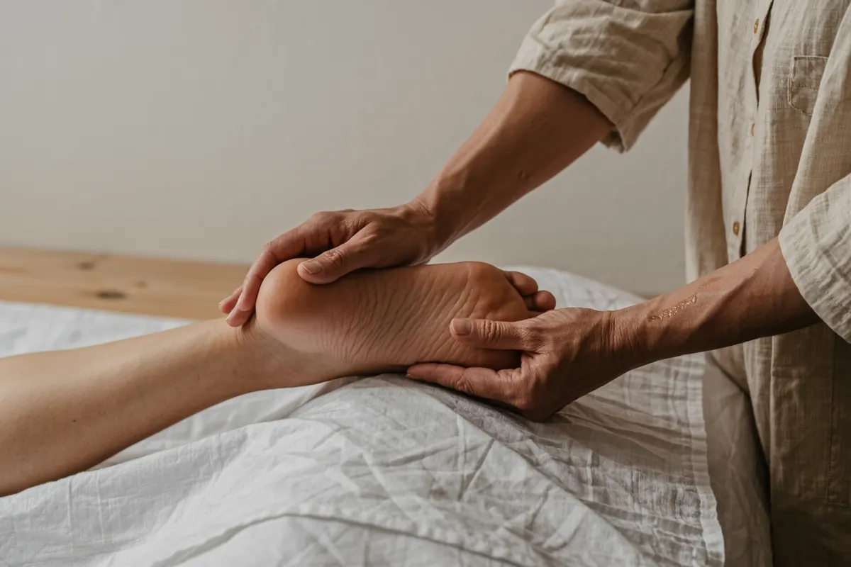 Pression du pouce sur la voûte plantaire lors d'une séance de réflexologie